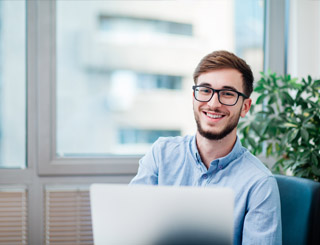 Young male apprentice with laptop in a classroom
